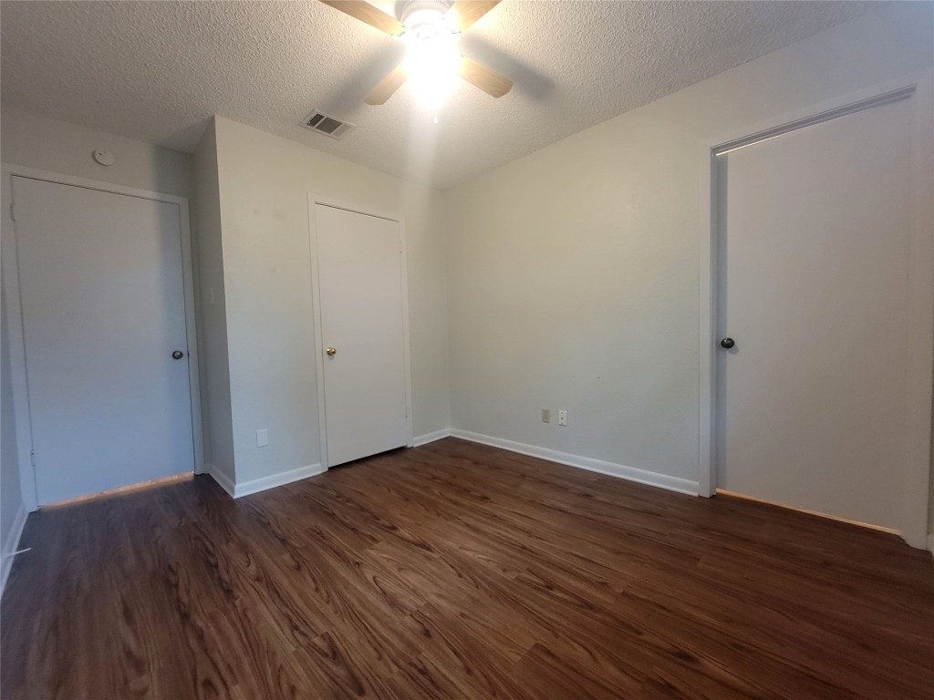 7825 Beauregard Circle, Unit 2A Austin, TX 78745 - Photo 24 of 27 an empty room with wooden floor and windows