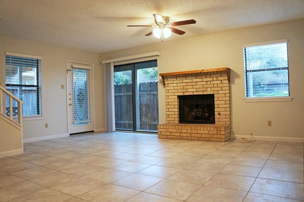 7825 Beauregard Circle, Unit 2A Austin, TX 78745 - Photo 4 of 27 a view of an empty room with a fireplace and a window