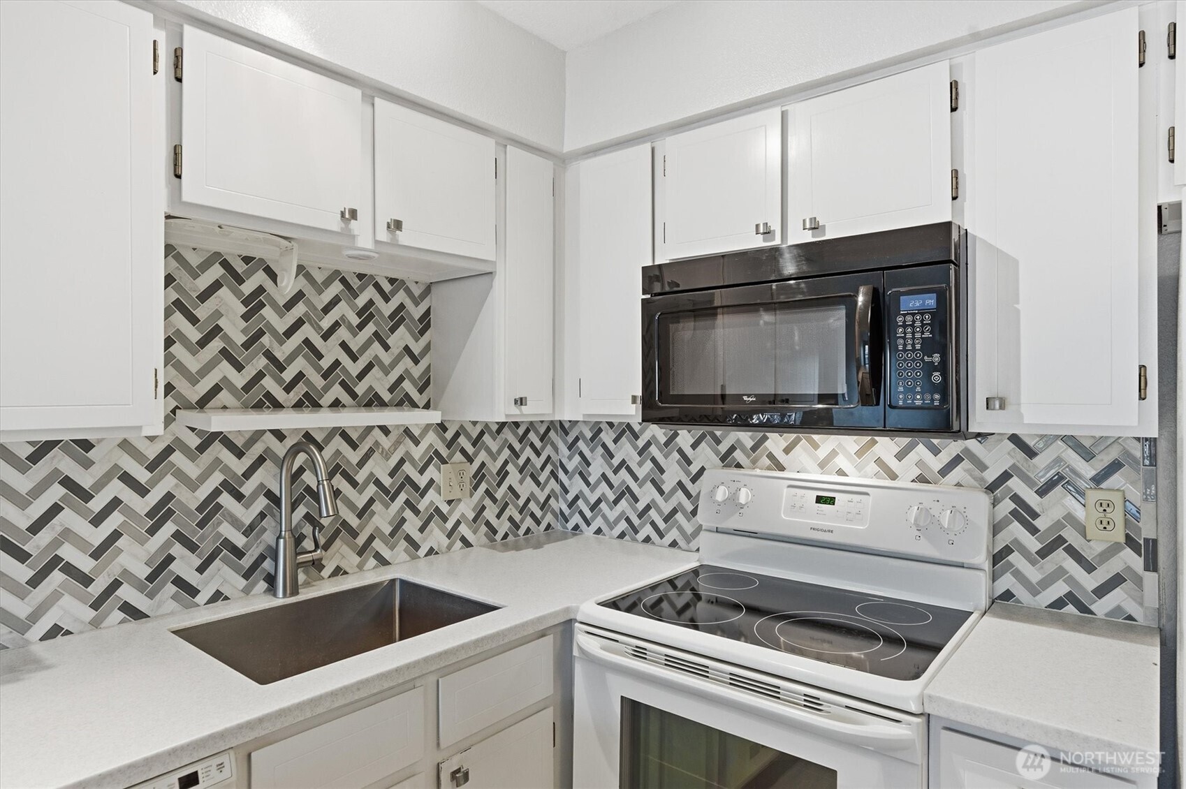 2005 Tibbetts Drive, Unit 209 Longview, WA 98632 - Photo 22 of 40 a kitchen with granite countertop white cabinets and black appliances