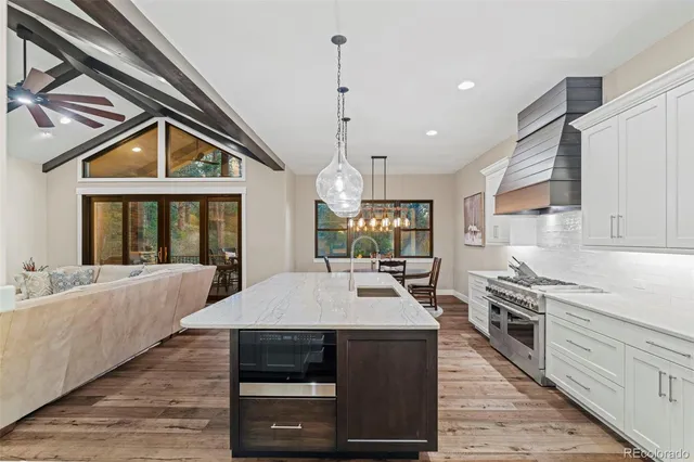 a kitchen with a stove a sink a microwave and windows