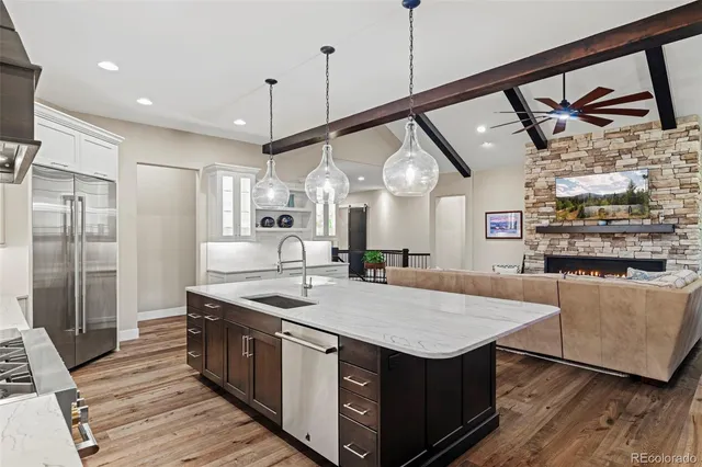 a kitchen with stainless steel appliances granite countertop a sink a stove and a refrigerator