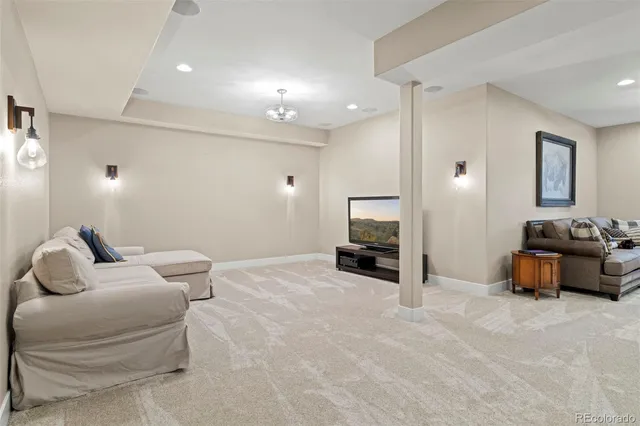 a large white kitchen with stainless steel appliances kitchen island a large counter top and a fireplace