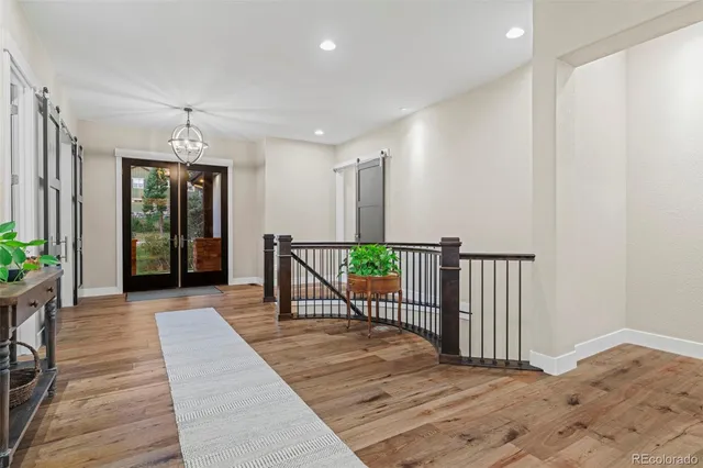 a view of a hallway with wooden floor and windows