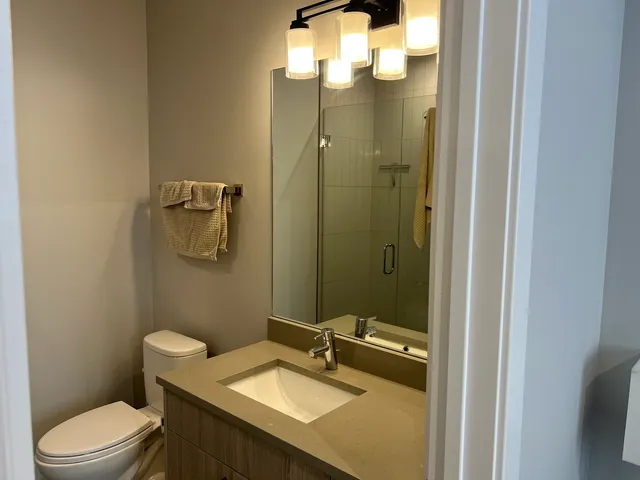 a bathroom with a sink a toilet and shower