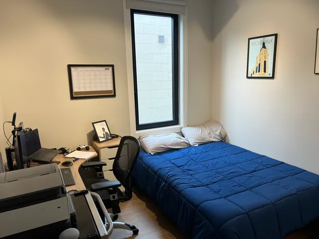 a bedroom with a bed and a desk
