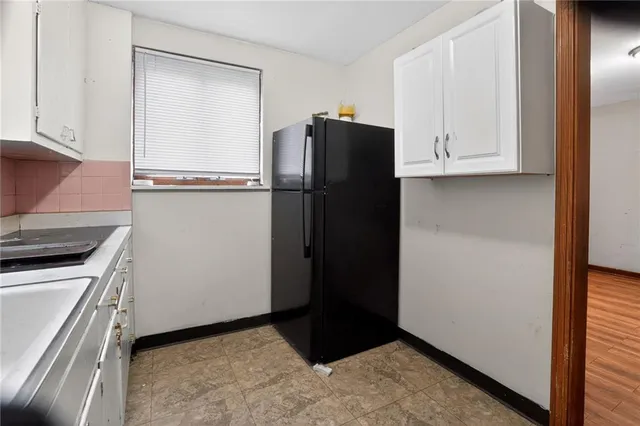 a view of a kitchen with refrigerator and cabinet