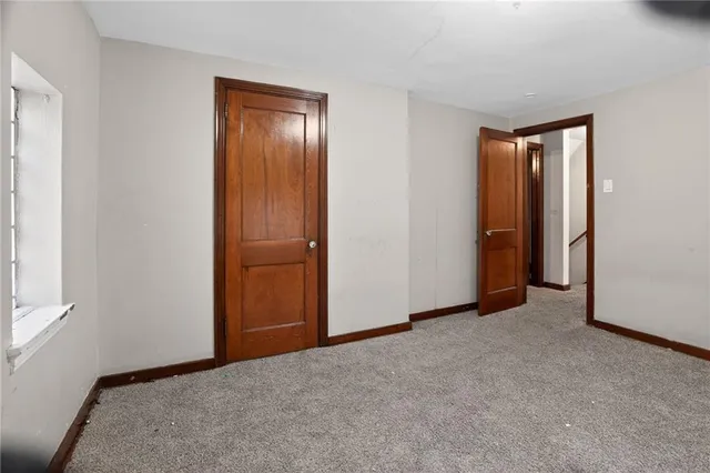 an empty room with closet and mirror