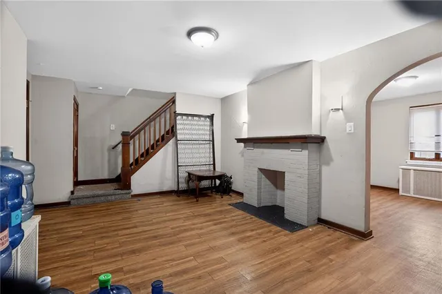 a view of a livingroom with wooden floor and a fireplace