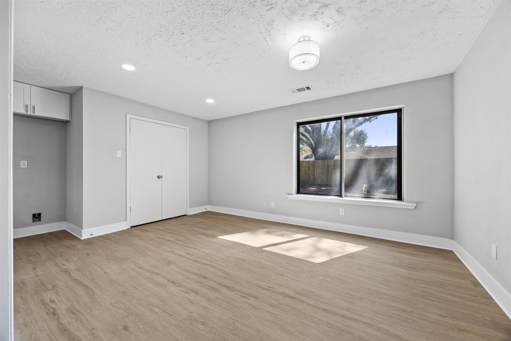 3030 Becket Street Pearland, TX 77584 - Photo 12 of 22 an empty room with wooden floor and windows