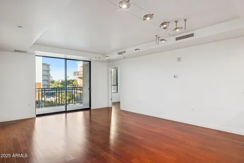 a kitchen with stainless steel appliances granite countertop a refrigerator a stove and a sink with wooden floor