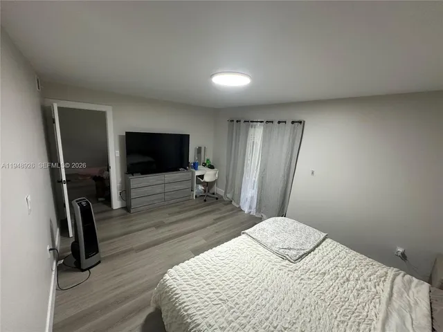a bedroom with a bed and a flat screen tv