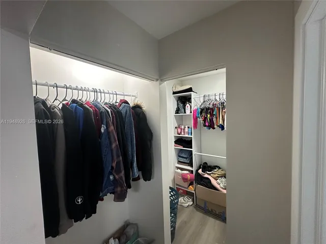 a view of walk in closet with clothes and shoes