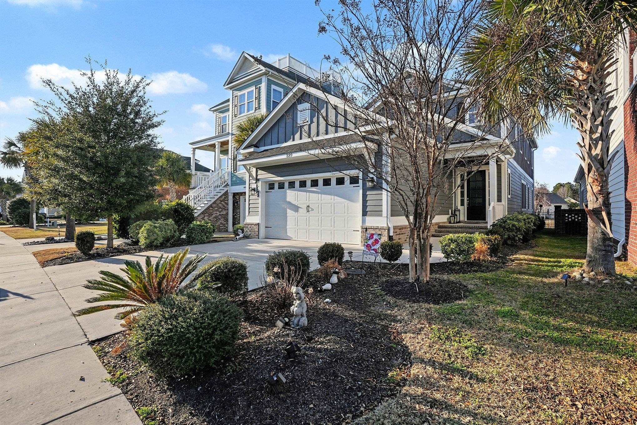 889 Crystal Water Way Myrtle Beach, SC 29579 - Photo 1 of 40 View of front of house with driveway, board and batten siding, an attached garage, brick siding, and stairs
