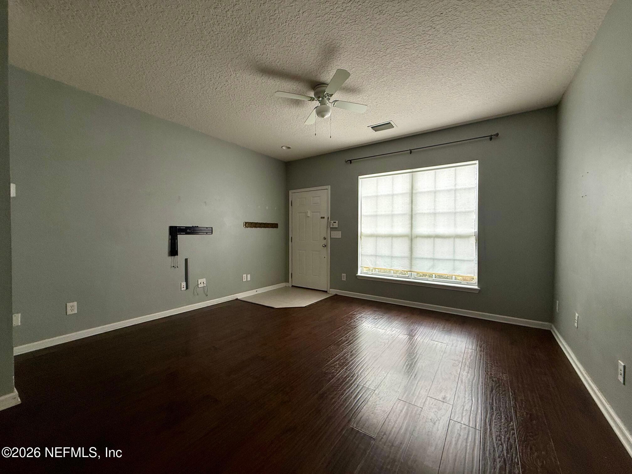 3585 Pebble Path Lane Jacksonville, FL 32224 - Photo 3 of 16 an empty room with wooden floor and windows