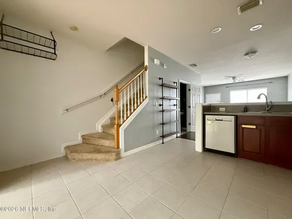 a view of a kitchen with stairs and an empty room