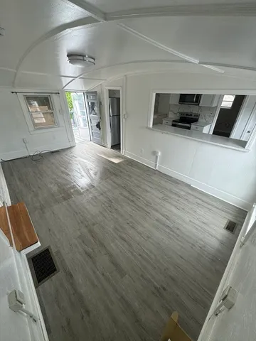 a view of a livingroom with an empty space and wooden floor