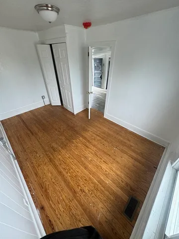 a bedroom with a bed and wooden floor