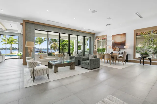 a dining room with furniture large windows and a chandelier