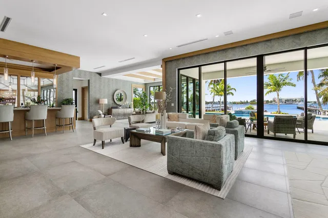 a living room with furniture a large window and stainless steel appliances