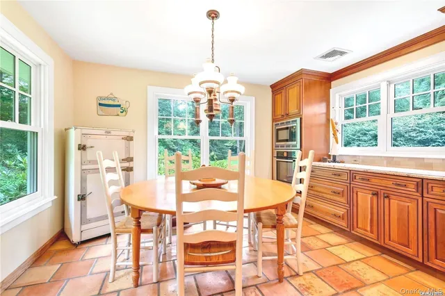a dining room with furniture a chandelier and wooden floor