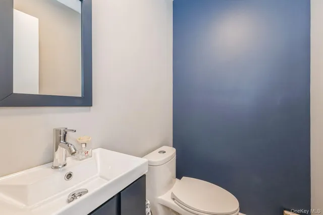 a bathroom with a sink a toilet and mirror