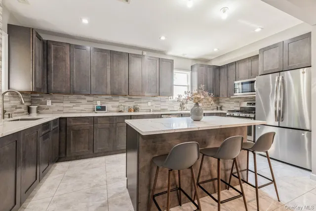 a kitchen with kitchen island a sink counter and chairs