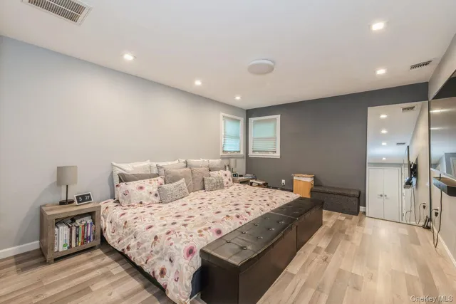 a large bedroom with a bed and wooden floor