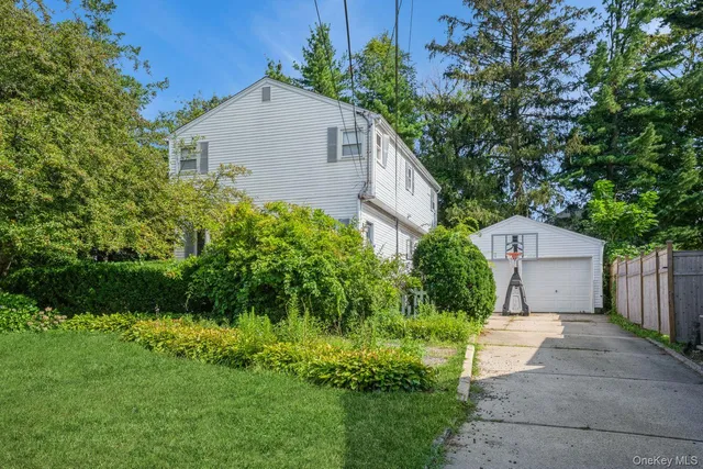 a front view of a house with a yard and potted plants