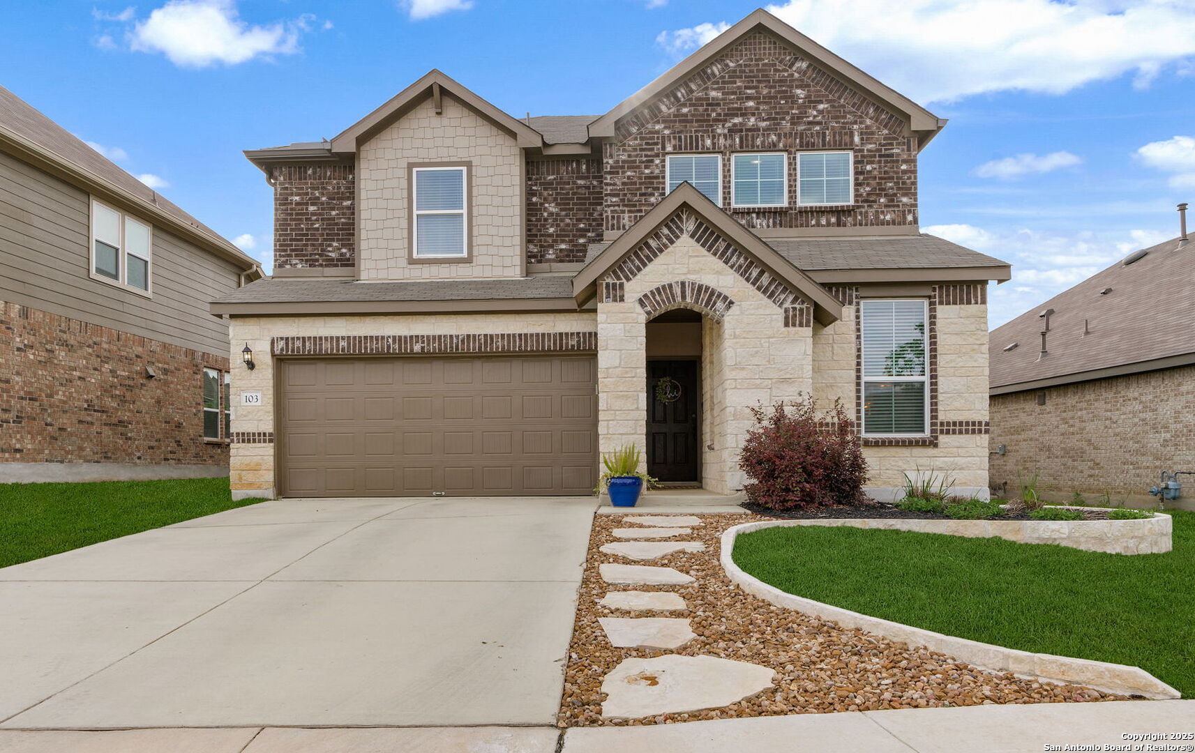 a front view of a house with a garden and yard