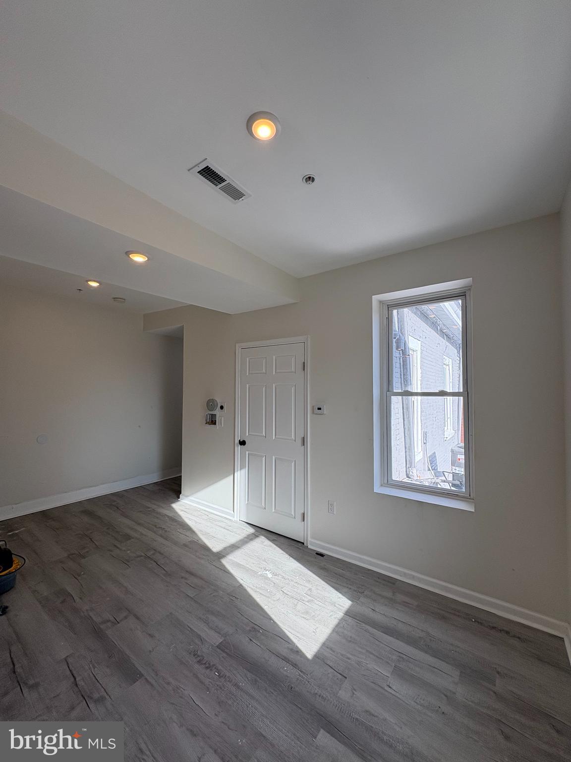 3625 North 22nd Street, Unit 2 Philadelphia, PA 19140 - Photo 2 of 10 a view of an empty room with wooden floor and a window