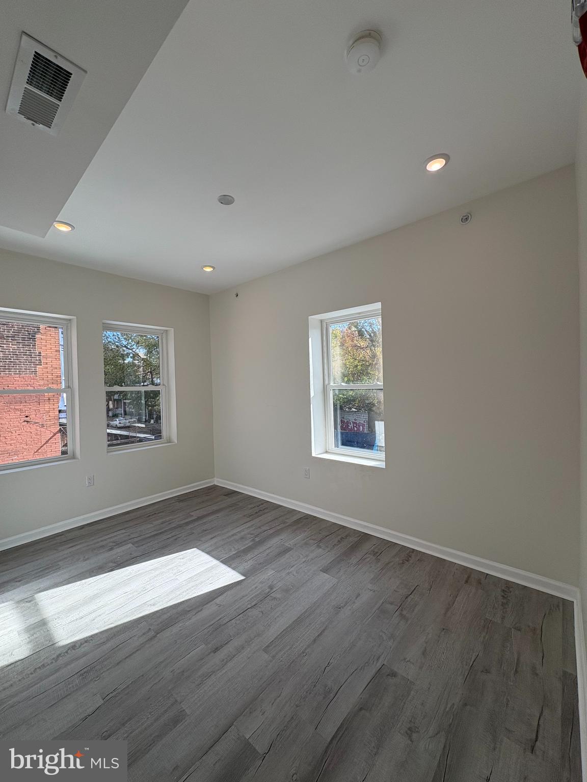 3625 North 22nd Street, Unit 2 Philadelphia, PA 19140 - Photo 6 of 10 an empty room with wooden floor and windows