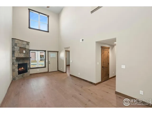 a view of an empty room with a window and fireplace