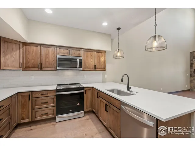 a kitchen with a sink a stove a microwave and wooden cabinets