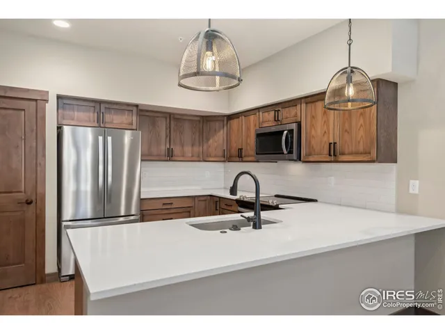 a kitchen with kitchen island a sink stainless steel appliances and cabinets