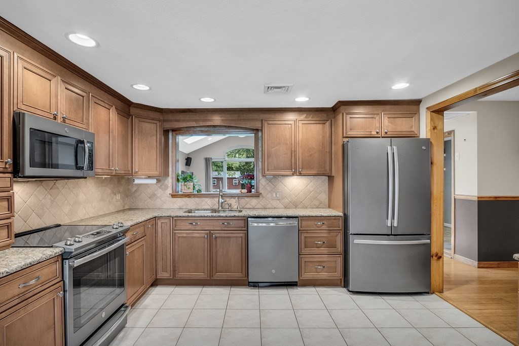 5 Colby Road Danvers, MA 01923 - Photo 10 of 33 a kitchen with stainless steel appliances granite countertop a refrigerator and a stove top oven