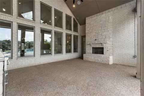 a view of an empty room with a fireplace and a ceiling fan