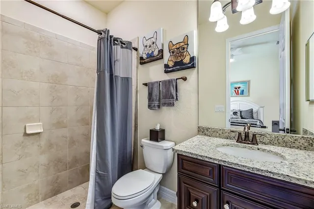 a bathroom with a granite countertop sink toilet and shower