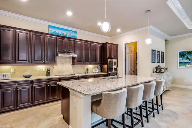 a kitchen with stainless steel appliances granite countertop table chairs sink and cabinets