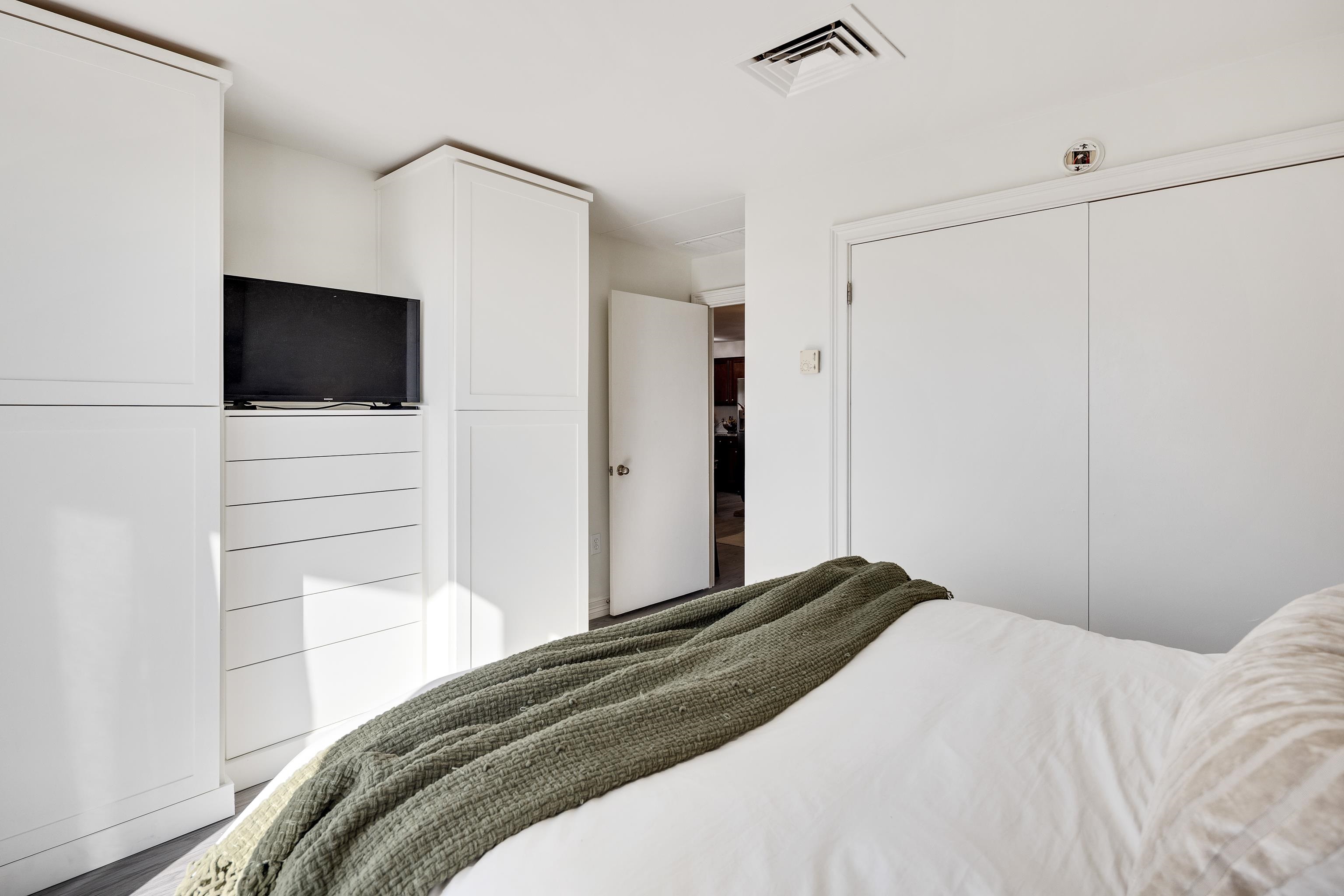 655 Riverside Drive, Unit 708A Memphis, TN 38103 - Photo 19 of 30 a bedroom with a bed and a flat screen tv