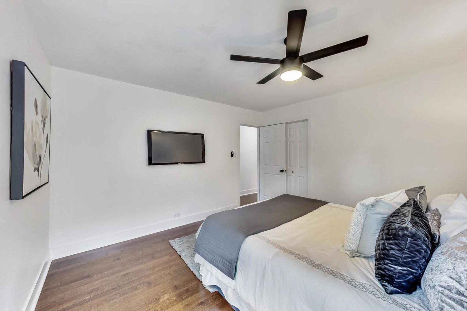 1211 West Talcott Road Park Ridge, IL 60068 - Photo 25 of 57 a spacious bedroom with a bed and a ceiling fan