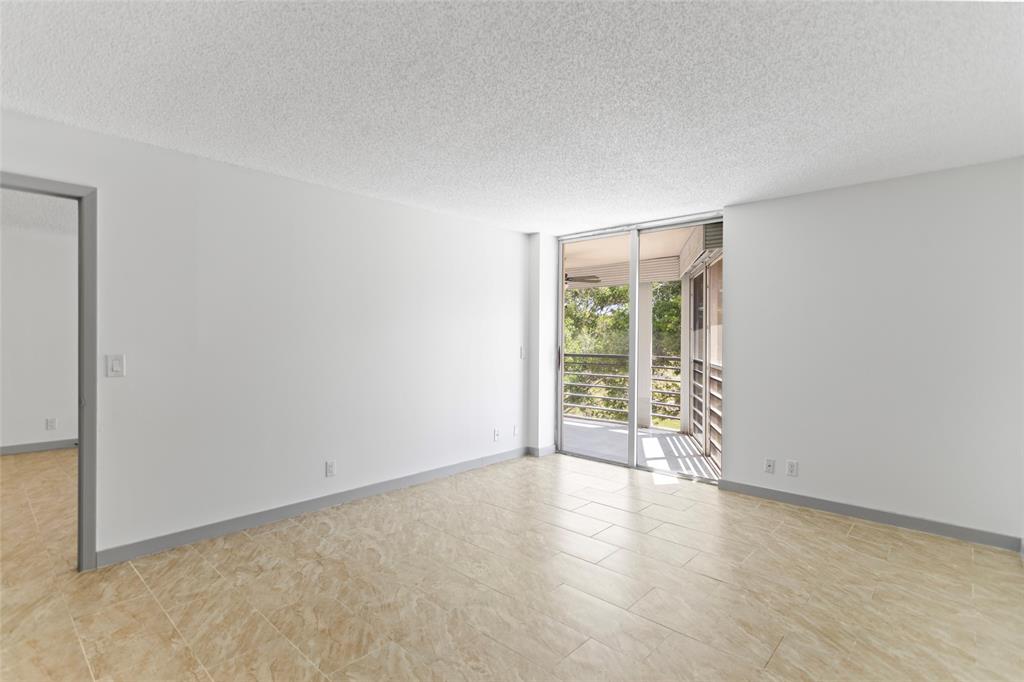 6300 Northwest 2nd Avenue, Unit 405 Boca Raton, FL 33487 - Photo 15 of 37 an empty room with wooden floor and windows