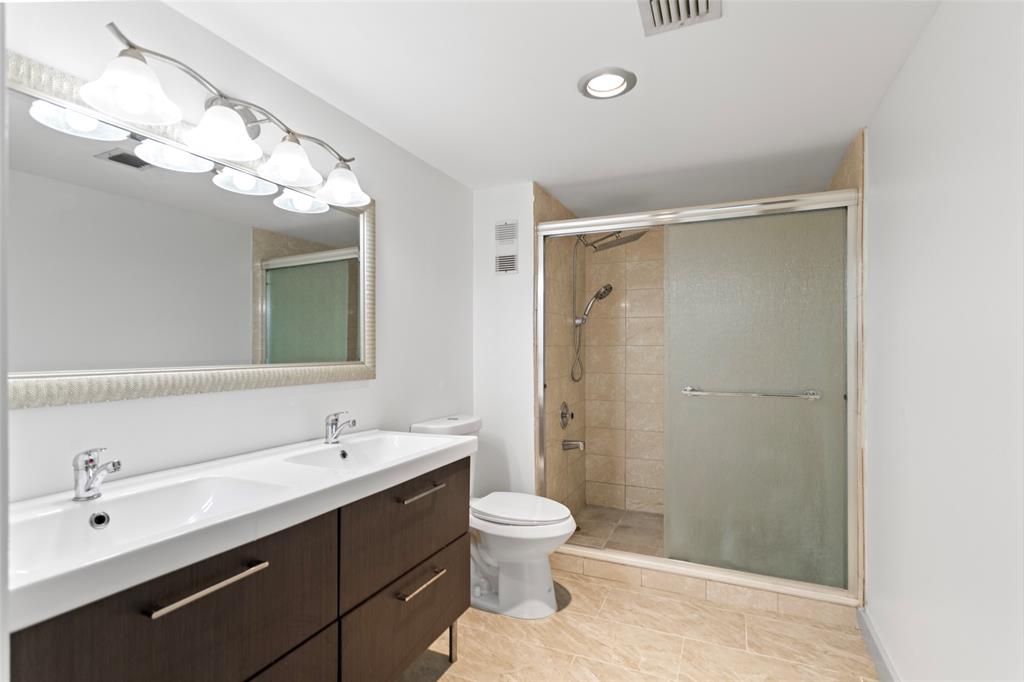 6300 Northwest 2nd Avenue, Unit 405 Boca Raton, FL 33487 - Photo 18 of 37 a bathroom with a double vanity sink mirror and toilet