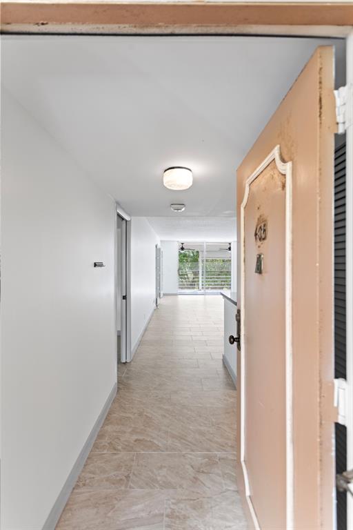 6300 Northwest 2nd Avenue, Unit 405 Boca Raton, FL 33487 - Photo 3 of 37 a view of a hallway with wooden floor and entryway