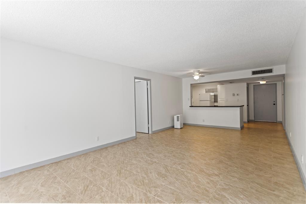 6300 Northwest 2nd Avenue, Unit 405 Boca Raton, FL 33487 - Photo 4 of 37 a view of an empty room and a kitchen