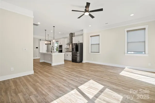 a view of a living room with wooden floor and ceiling fan