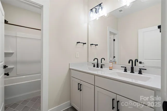 an empty room with windows and ceiling fan