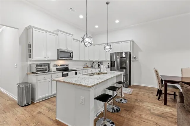 a kitchen with white cabinets and stainless steel appliances