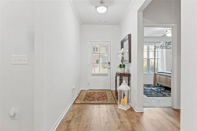 a view of a hallway with wooden floor and a livingroom