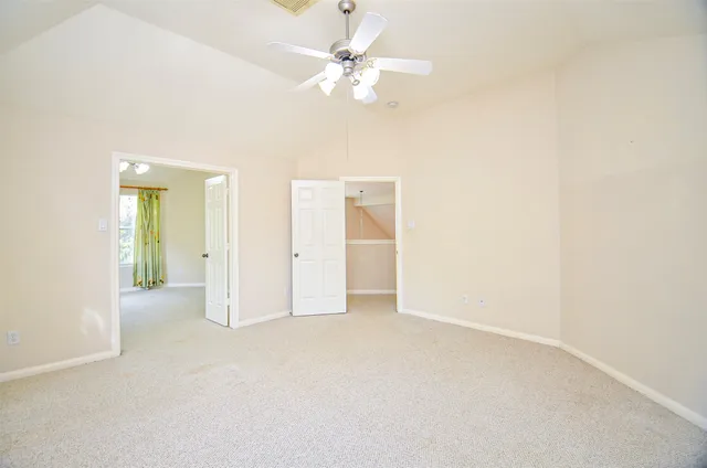 an empty room with a ceiling fan and a window
