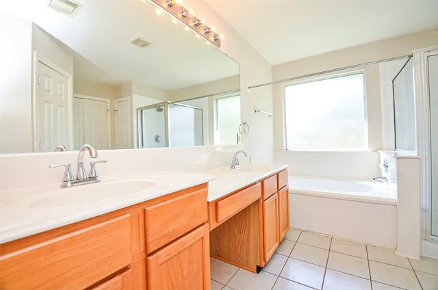 a bathroom with a granite countertop sink and a bathtub